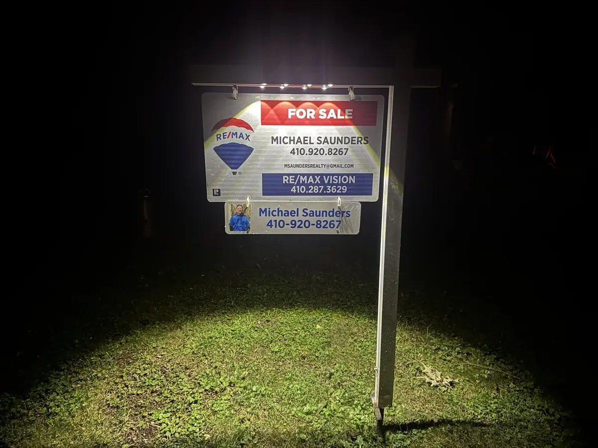 Tri-State Negotiator RE/MAX Vision for sale sign glowing at night under its solar light